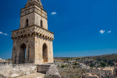 Matera, Basilicata, İtalya - San Pietro Barisano mağara kilisesinin çan kulesi, arka planda Murgia Materana Parkı.