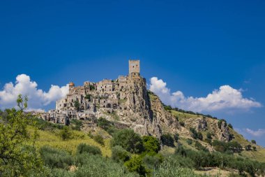 Craco, Matera, Basilicata, İtalya. Hayalet kasaba bir heyelan sonrasında yok edildi ve terk edildi. Tepenin üstüne inşa edilmiş antik köyün kalıntıları ve kalıntıları görünüyor. Gözetleme kulesi tepede.