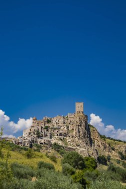 Craco, Matera, Basilicata, İtalya. Hayalet kasaba bir heyelan sonrasında yok edildi ve terk edildi. Tepenin üstüne inşa edilmiş antik köyün kalıntıları ve kalıntıları görünüyor. Gözetleme kulesi tepede.