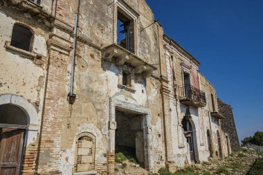 Craco, Matera, Basilicata, İtalya. Bir heyelan sonucu hayalet kasaba yok edildi ve terk edildi. Çökmüş evler ve bitkiler tarafından istila edilmiş kalıntılar. Kırık duvarlar, pencereler ve kapılar, çökmüş balkonlar.