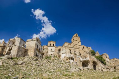 Craco, Basilicata, İtalya. Bir heyelan sonucu hayalet kasaba yok edildi ve terk edildi. Çökmüş evler ve bitkiler tarafından istila edilmiş kalıntılar. Kırık duvarlar, pencereler ve kapılar. Kilisenin çan kulesi.