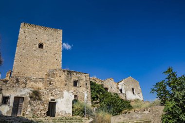 Craco, Matera, Basilicata, İtalya. Hayalet kasaba bir heyelan tarafından yok edildi. Çökmüş evler ve bitkiler tarafından istila edilmiş kalıntılar. Eski gözetleme kulesi hala ayakta şehre bakıyor..