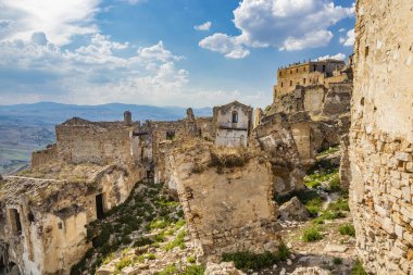 Craco, Matera, Basilicata, İtalya. Hayalet kasaba bir heyelan sonrasında yok edildi ve terk edildi. Çökmüş evler ve kalıntılar bitki örtüsü, taş ve enkaz tarafından istila edildi. Kırık kapı ve pencereler.
