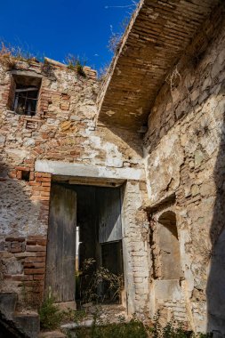 Craco, Matera, Basilicata, İtalya. Hayalet kasaba bir heyelan sonrasında yok edildi ve terk edildi. Çökmüş evler ve kalıntılar bitki örtüsü, taş ve enkaz tarafından istila edildi. Kırık kapı ve pencereler.