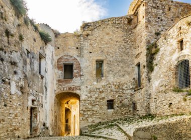 Craco, Matera, Basilicata, İtalya. Hayalet kasaba bir heyelan sonrasında yok edildi ve terk edildi. Çökmüş evler ve kalıntılar bitki örtüsü, taş ve enkaz tarafından istila edildi. Kırık kapı ve pencereler.