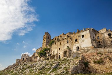 Craco, Basilicata, İtalya. Bir heyelan sonucu hayalet kasaba yok edildi ve terk edildi. Çökmüş evler ve bitkiler tarafından istila edilmiş kalıntılar. Kırık duvarlar, pencereler ve kapılar. Kilisenin çan kulesi.