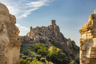 Craco, Matera, Basilicata, İtalya. Hayalet kasaba bir heyelan sonrasında yok edildi ve terk edildi. Tepenin üstüne inşa edilmiş antik köyün kalıntıları ve kalıntıları görünüyor. Gözetleme kulesi tepede.
