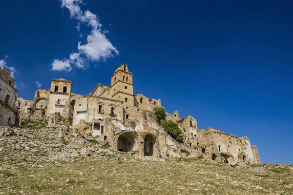 Craco, Basilicata, İtalya. Bir heyelan sonucu hayalet kasaba yok edildi ve terk edildi. Çökmüş evler ve bitkiler tarafından istila edilmiş kalıntılar. Kırık duvarlar, pencereler ve kapılar. Kilisenin çan kulesi.
