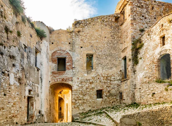 Craco, Matera, Basilicata, İtalya. Hayalet kasaba bir heyelan sonrasında yok edildi ve terk edildi. Çökmüş evler ve kalıntılar bitki örtüsü, taş ve enkaz tarafından istila edildi. Kırık kapı ve pencereler.