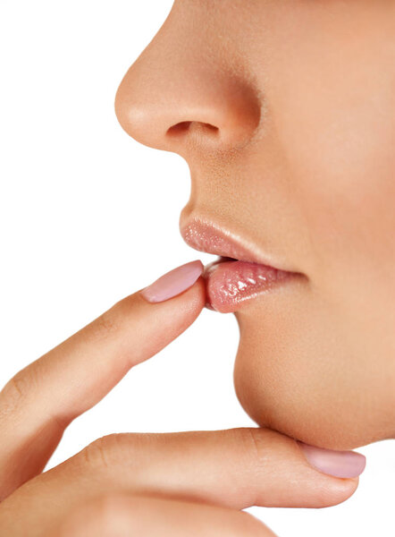 Палец на сексуальные губы женщины, привлекательная молодая женщина, применяющая бальзам для губ изолирован на белом фоне
