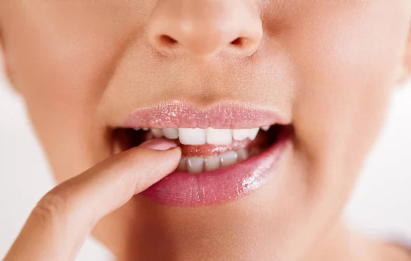 歯で指を噛んで挑発的な女性の唇のクローズ アップ — ストック写真