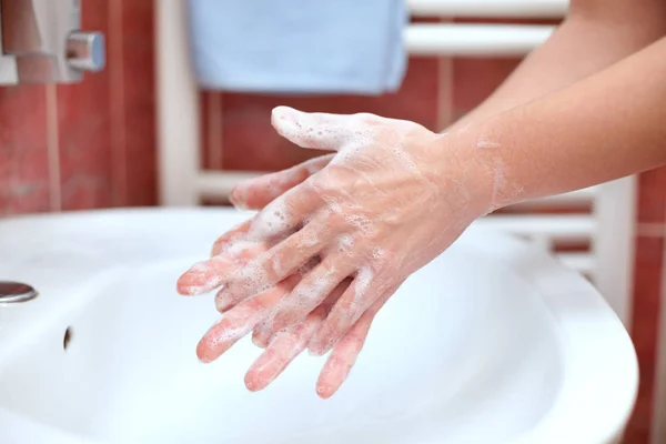 Hand cleaning in bathroom. Soapy hands. Hand washing.