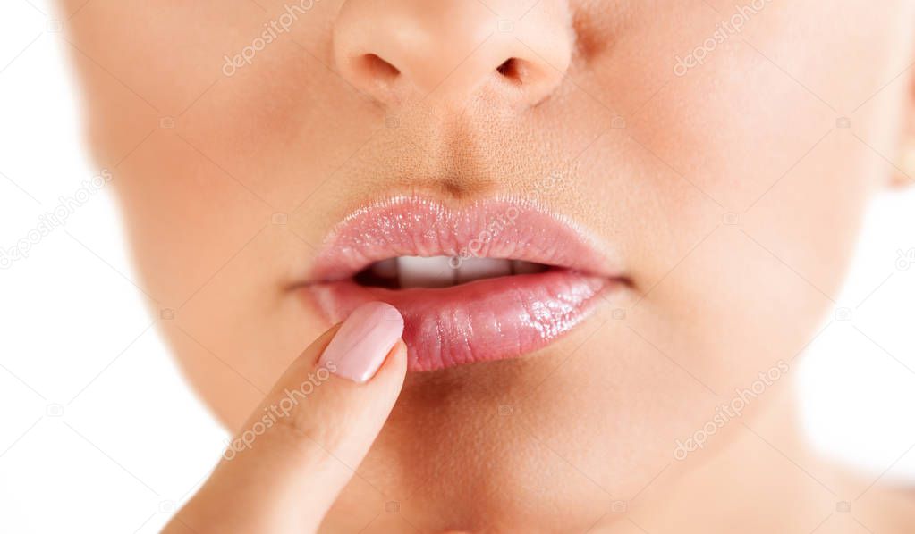 herpes on the lips, part of a woman's face with finger on lips with herpes, beauty concept