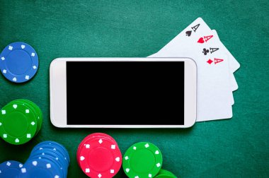 Smartphone, dört as ve çip kartlar masada. Online kumar. Kumar oyunları.