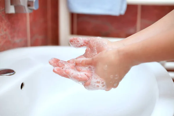 Washing hands with soap in bathroom. Soapy hands.