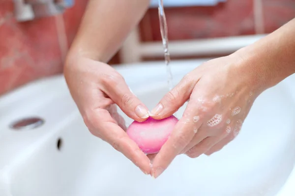 Hands with soap making heart shape. Hand protection and hygiene.