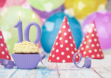 Parti şapkaları ve masada mavi kurdele ile onuncu doğum günü için tek muffin