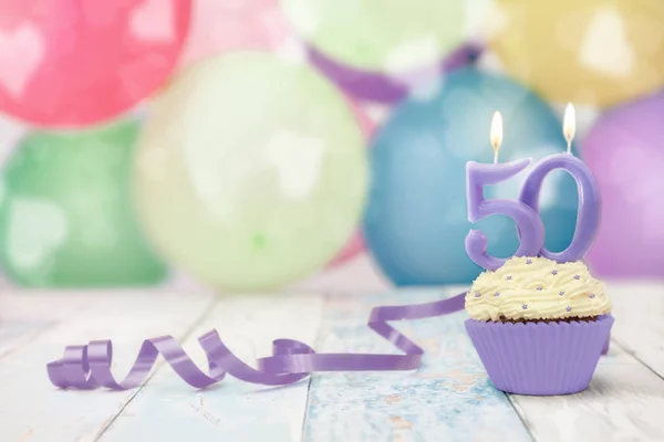 50 anniversary birthday muffin with candle and balloons