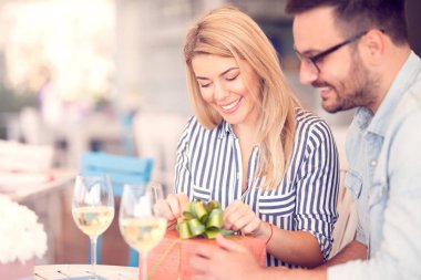 Kafe barda oturmuş güzel genç bir çift. Onun kız arkadaşı veya karısı, Sevgililer günü, Doğum günü, yıldönümü hediye veren adam