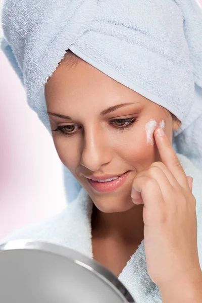 Beauty skincare, young woman in bathrobe applying moisturizing cream