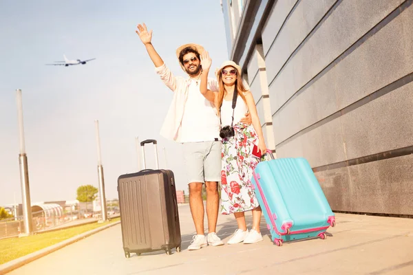 Love couple at the airport say goodbye to a friends and going to vacation, holiday, honeymoon, adventure