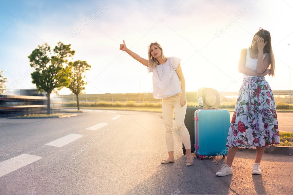 Unhappy girls stay on the road and must to hitchhike