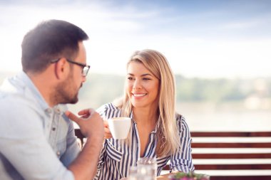 Genç gülümseyen içme sabah kafede, açık kahve çift