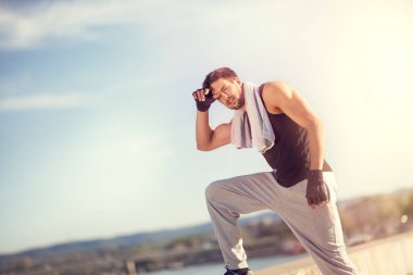 Egzersiz yaparken çok sıcak bir günde havlu ile yakışıklı erkekler