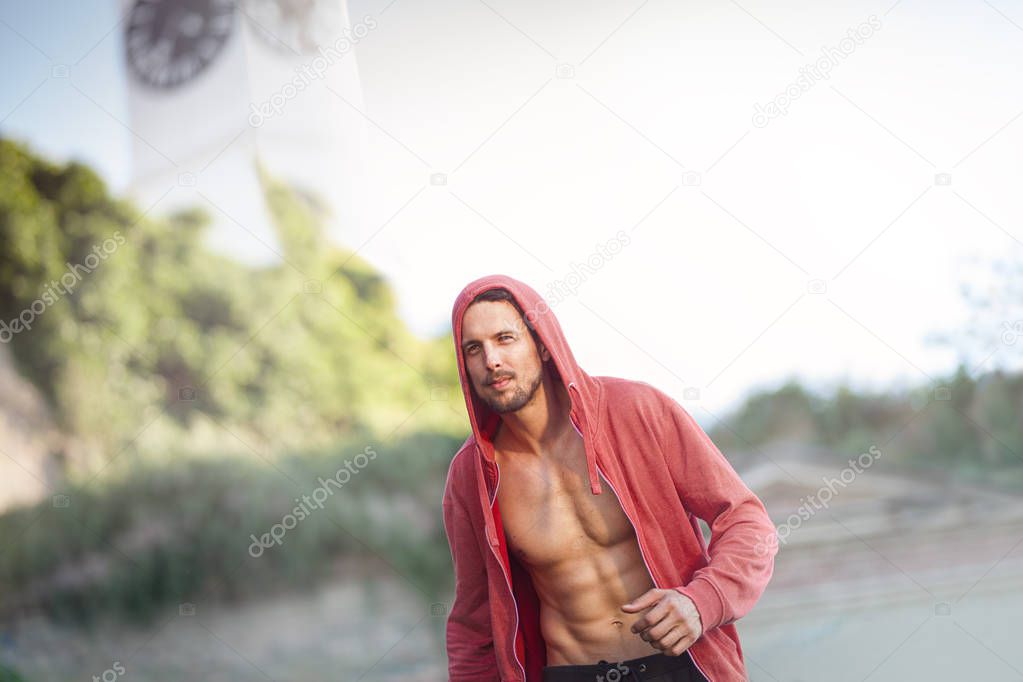 Man in red hoodie jogging the city park, urban healthy life 