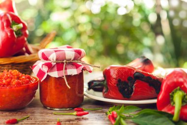 Ajvar plaka üzerinde közlenmiş biber kavanoz ve cam kase