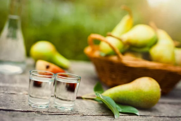 フルーツ ブランデーとテーブルに新鮮な梨のショット グラス — ストック写真