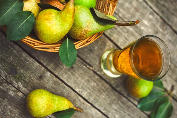 Fresh pears in basket with pear juice in glass on the table