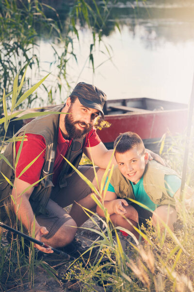 Happy father and son together on  fishing, prepare fishing equipment that will be taken to the boat