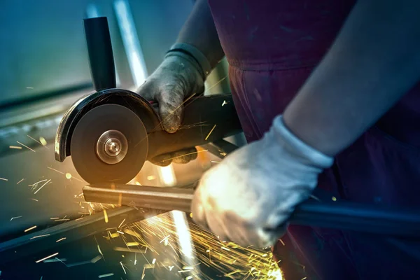 Close-up of electric grinder cutting metal with bright sparks