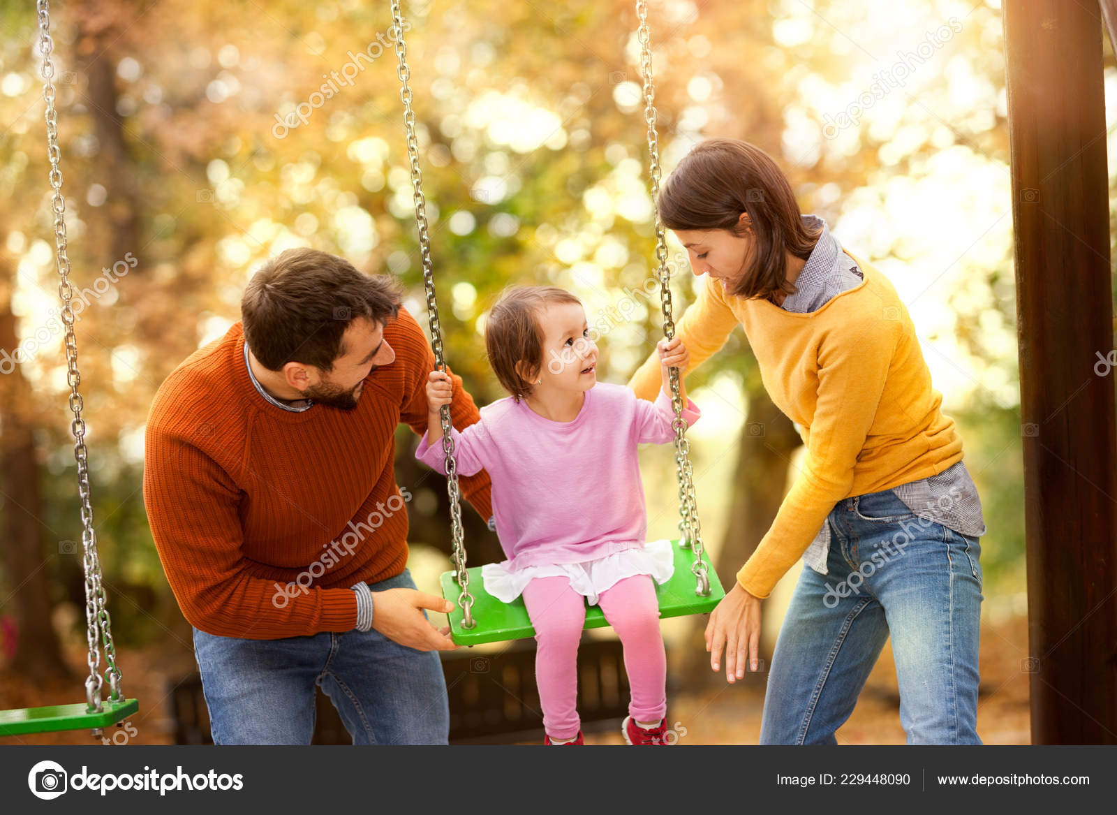 Young Little Girl Having Fun Swing His Mother Father