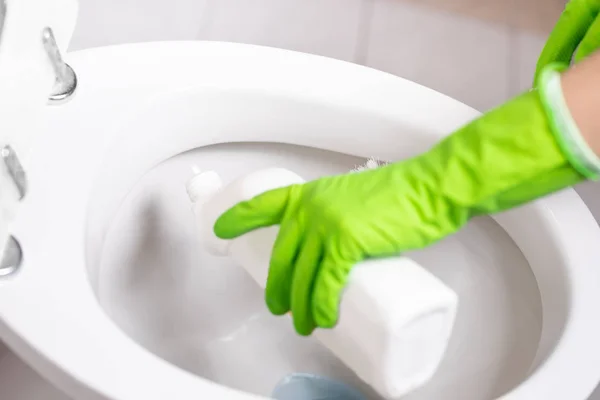 Ręka kobiety w zielonej rękawiczce sprzątanie WC — Zdjęcie stockowe