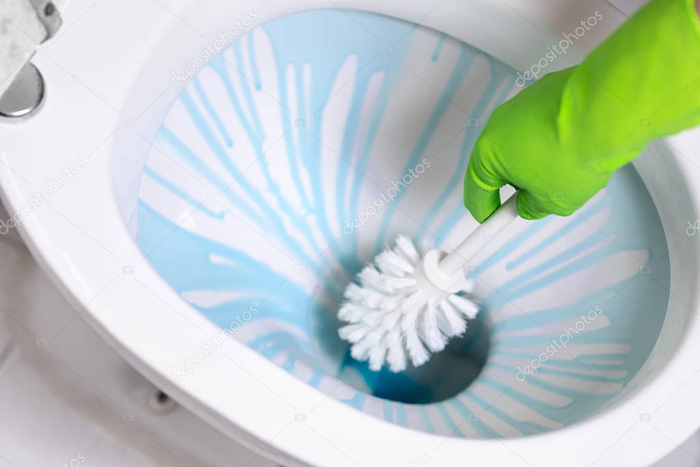 cleaning toilet bowl using brush and detergent