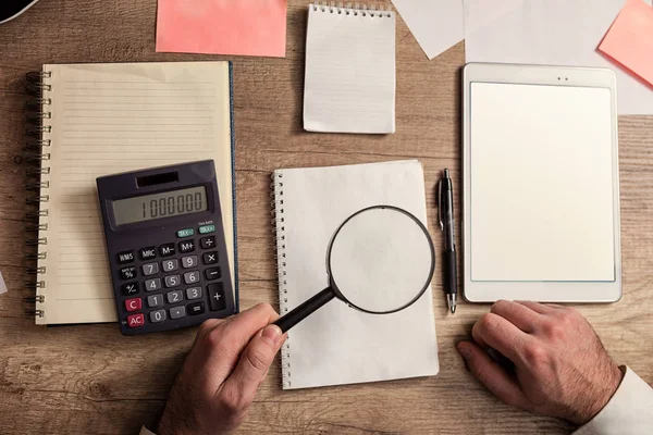 Financial documents with magnifying glass and calculator