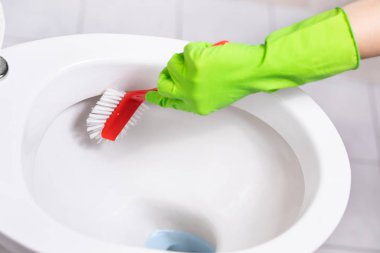 Kadın bir fırçalayın fırça ile bir banyo tuvalet temizler