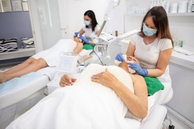 Anne ve onun yetişkin kızı kozmetik salonunda rahatlatıcı