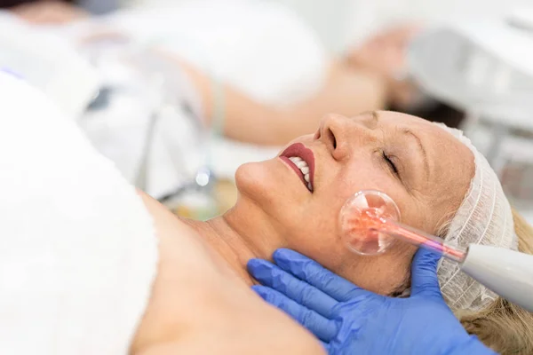 Mujer mayor recibiendo tratamiento facial en el salón de belleza —  Fotos de Stock