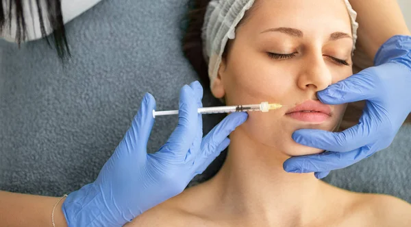 Mujer recibe la inyección de botox en sus labios — Foto de Stock