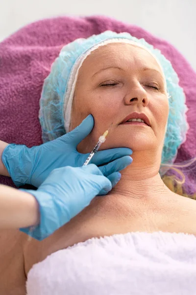 쾌활한 노인 여성은 보톡스 시술을 받고있다 — 스톡 사진