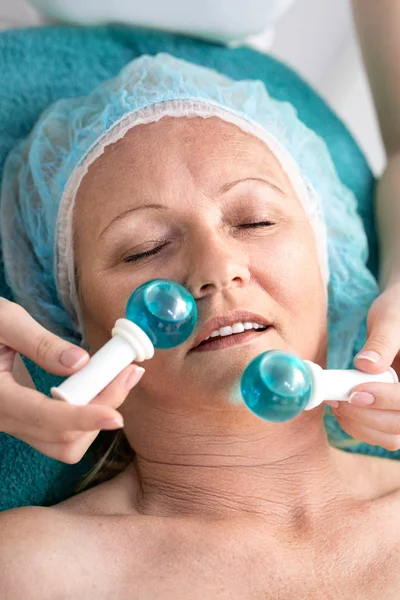 Mujer en salón de belleza durante el tratamiento con bolas de vidrio frío — Foto de Stock