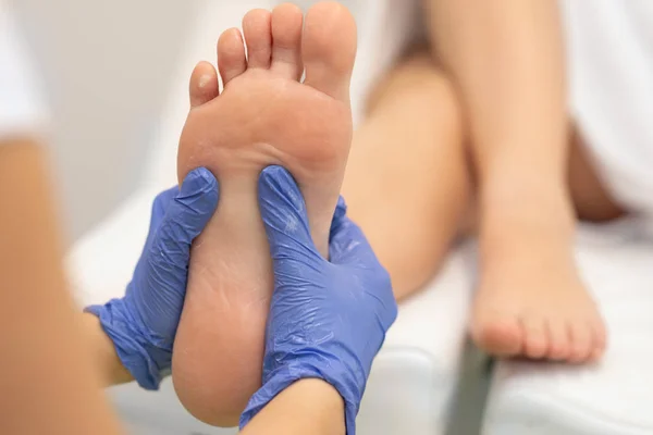 Массажист, делающий массаж ног в спа-салоне — стоковое фото