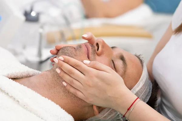 젊은 잘 생긴 남자 수신 얼굴 마사지 과 스파 치료 — 스톡 사진
