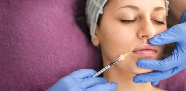 Hermosa mujer recibiendo inyección cosmética en los labios — Foto de Stock