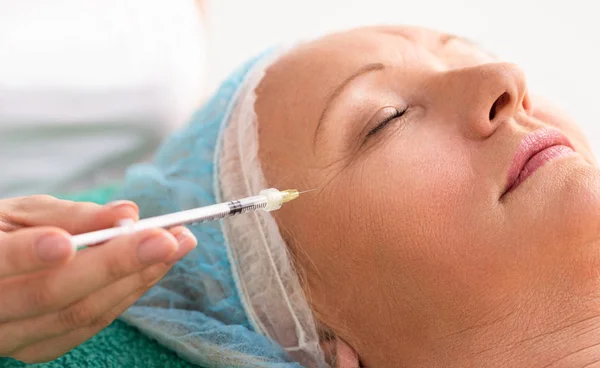 Mujer de pelo gris en clínica de belleza recibiendo Botox inyectable a remo — Foto de Stock