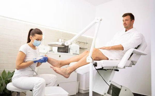 Young male in spa salon on pedicure treatment — Stock Photo, Image