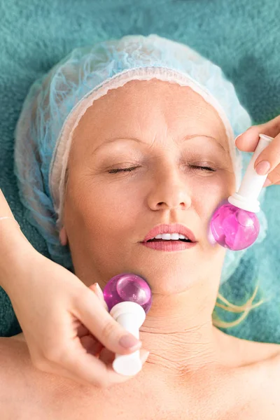 Mujer envejecida en el masaje de tratamiento de salón de belleza con un vidrio frío b — Foto de Stock